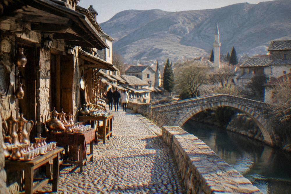 A single arch stone bridge over a quiet side stream in the old town of Mostar